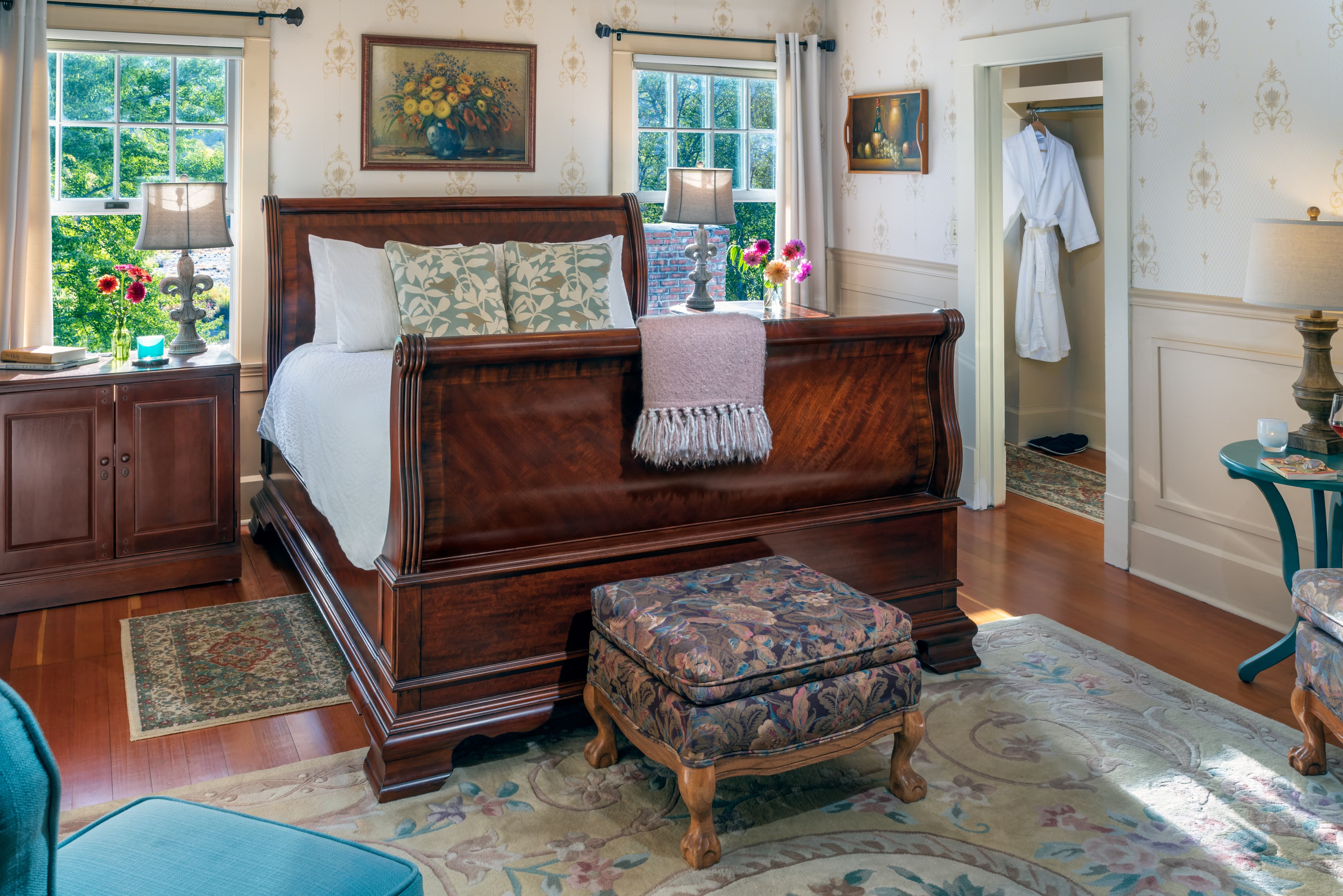 English room with queen bed, floral accents and bright windows