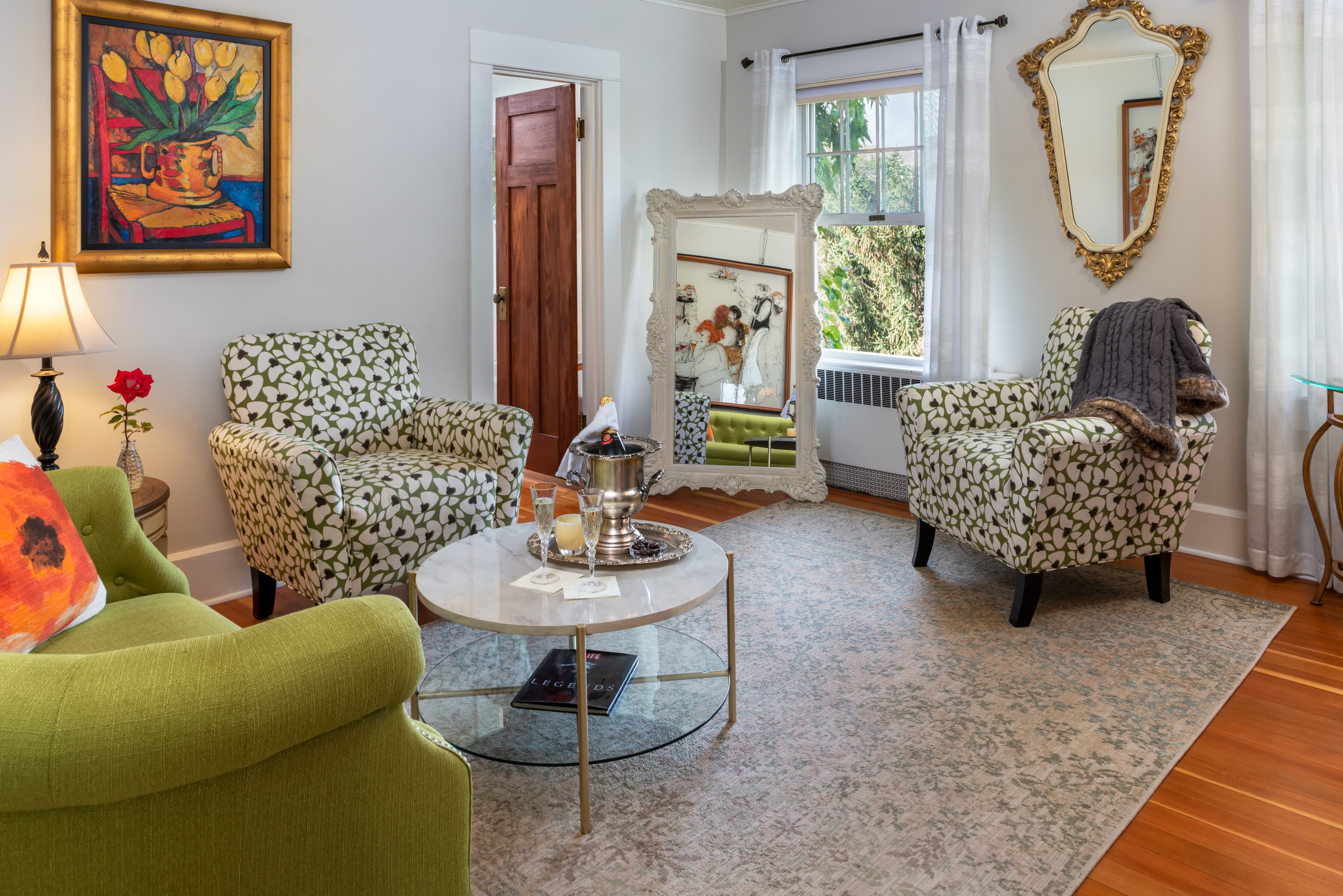 Garden Suite green love seat and marble coffee table with yellow tulips in a vase