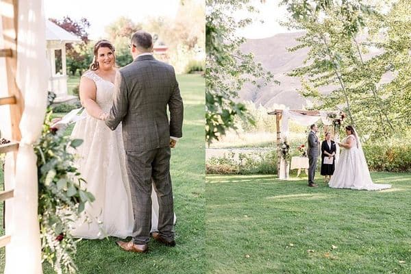 A couple stands together in an outdoor wedding ceremony surrounded by greenery.