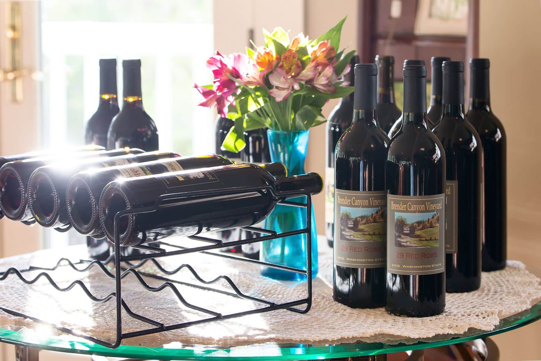 A display of wine bottles and a bouquet of flowers on a table.