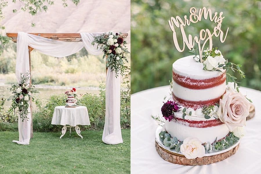 A decorated wedding altar with draped fabric and floral arrangements beside a two-tier cake featuring floral accents and a wooden topper.
